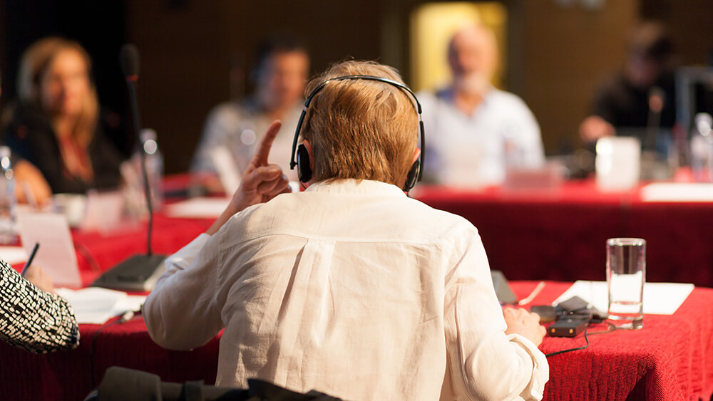 back of arguing man seated at conference table