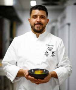 un hombre de barba oscura sosteniendo un plato de comida