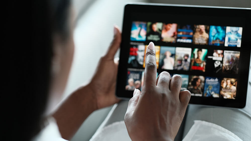 woman choosing film on computer pad