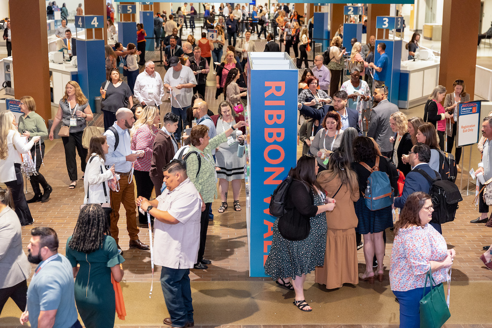 Attendees mill about the trade-show floor at the Annual Conference of the National Council for Mental Wellbeing.