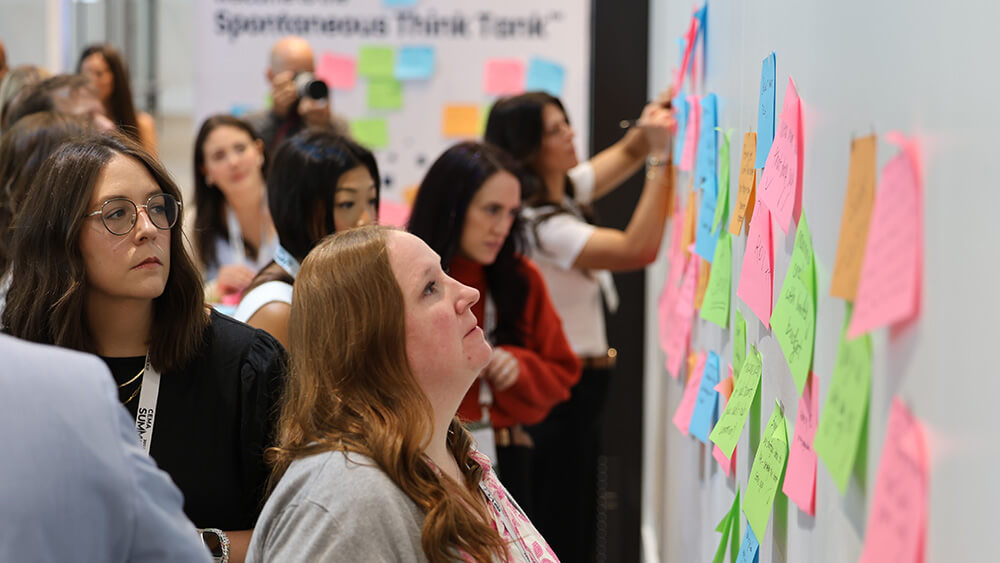 women posting sticky notes on wall