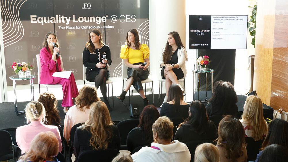 4-women panel on stage in front of seated group