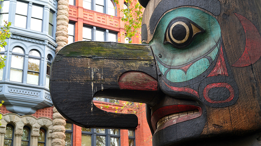 blue and red painted face and large nose of totem